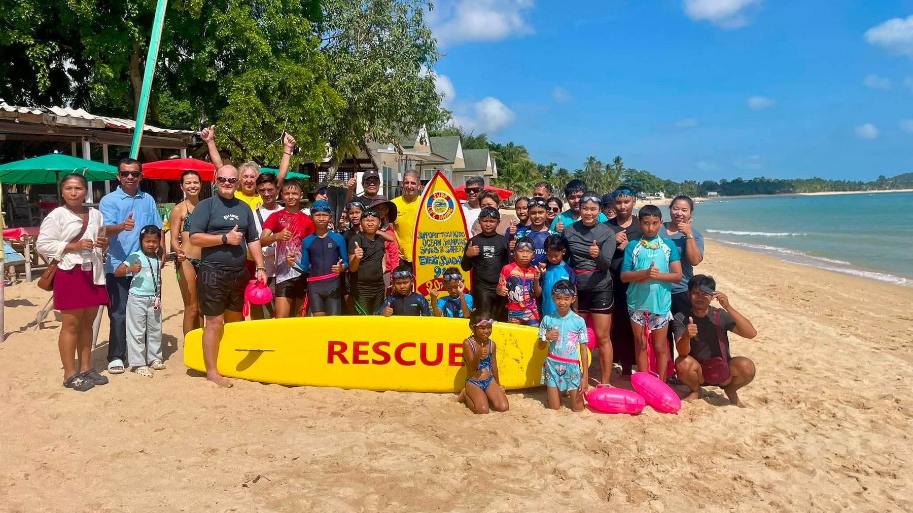Children and volunteers gathered behind a rescue board